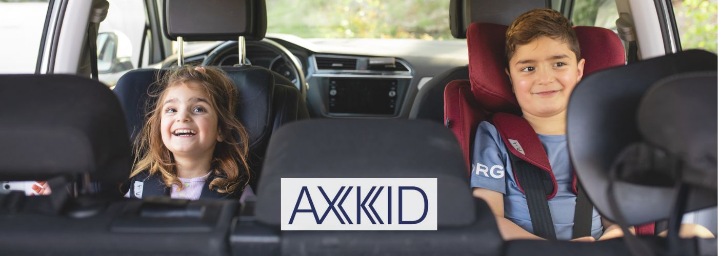 niños viajando a contramarcha en dos sillas Axkid